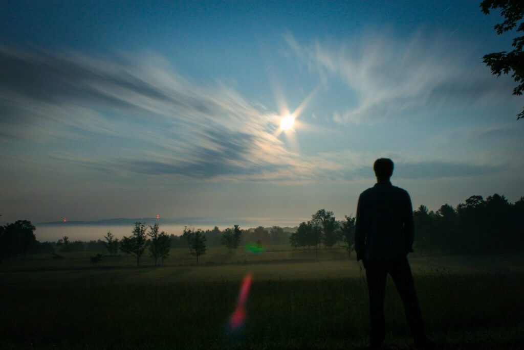 Silhouette standing against moving clouds